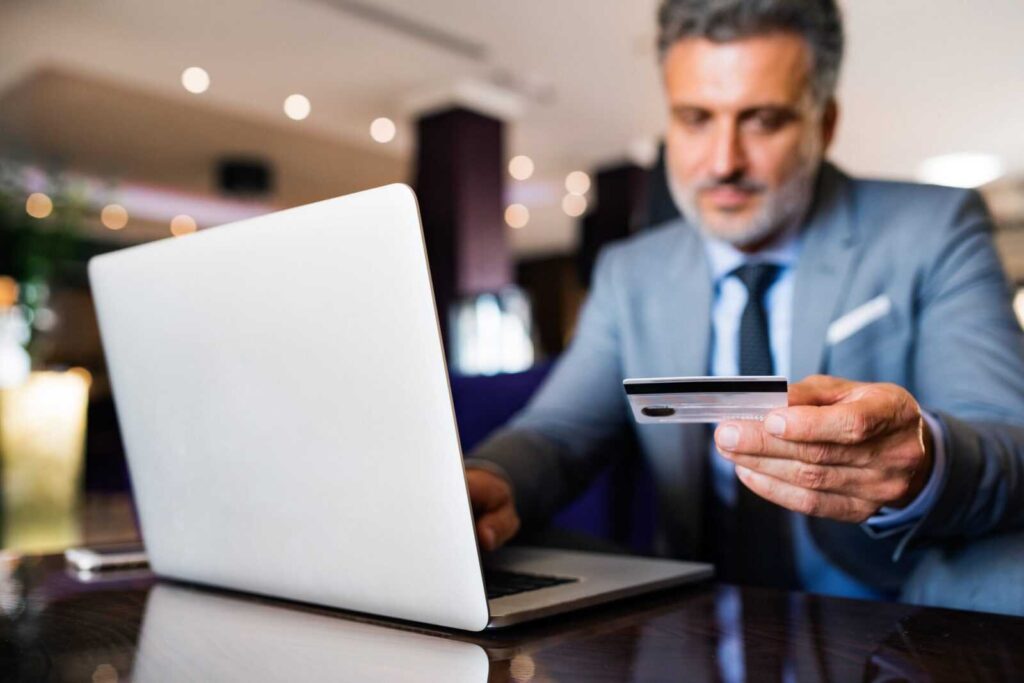 empresario-com-laptop-segurando-cartão-de-crédito